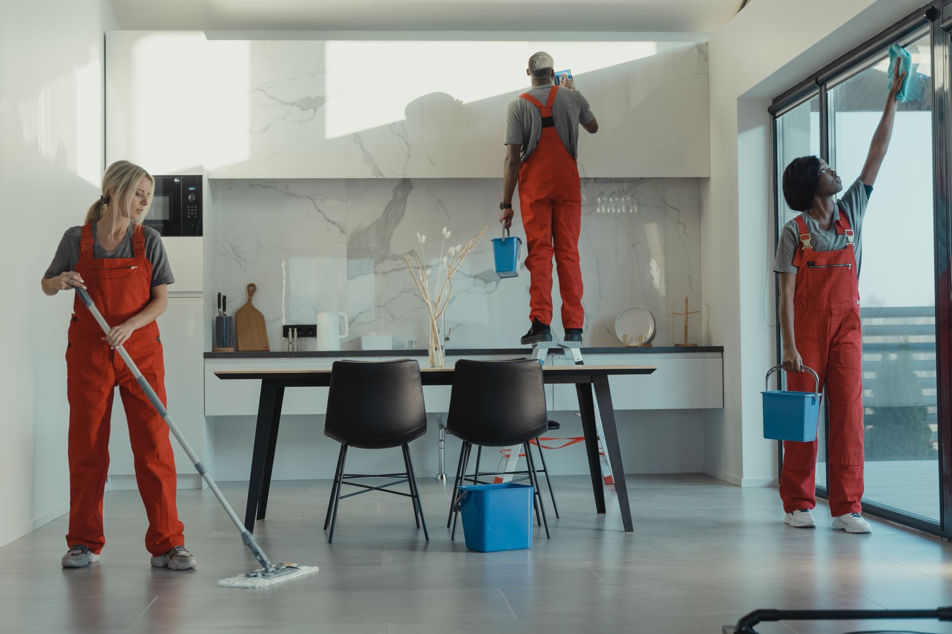 group of people cleaning a dining room